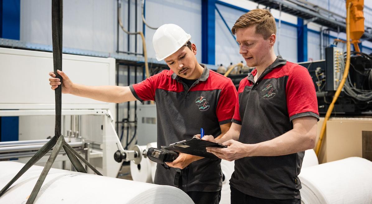 Taal werkt! Twee medewerkers in een fabriekshal