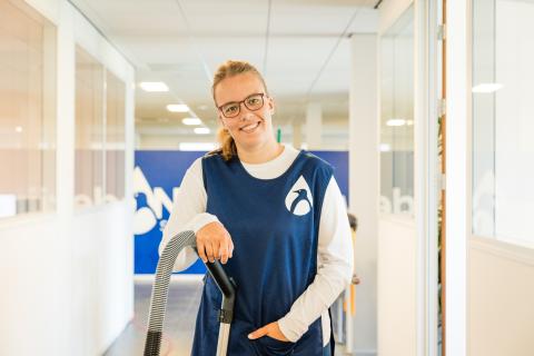 Taal werkt! Medewerker schoonmaak kijkt in camera